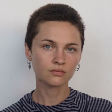 Headshot of Georgia Bowman, an adult person with a fair skin tone and close-shaved dark brown hair. 