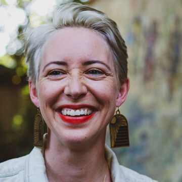 Kate Lechler, an adult person with a fair skin tone and a platinum pixie cut.