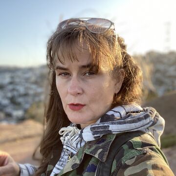 Portrait of Lisa Haller Baggesen, an adult person with a fair skin tone and long brown hair, standing outdoors.