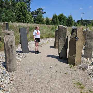 SAIC faculty member Sonya Bogdanova stands outside next to stone sculptures.
