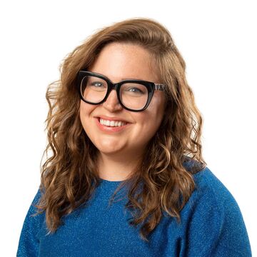 Headshot of Bri Beck, an adult person with a fair skin tone, shoulder-length wavy brown hair, and black glasses.