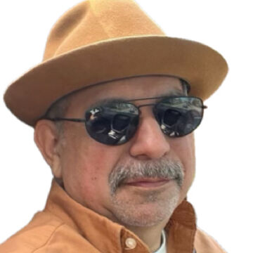 Arturo Barrera, an elder person with a medium-fair skin tone, sunglasses, and a gray mustache against a blank white background.