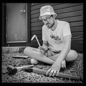 A black and white image of SAIC faculty member Johnny Doley working on a piece of wood.