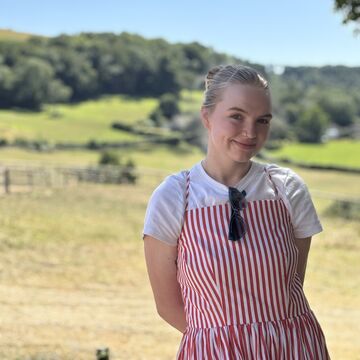 Marley Jane Anderson, a person with light skin and blond hair wearing a red and white striped dress outdoors.