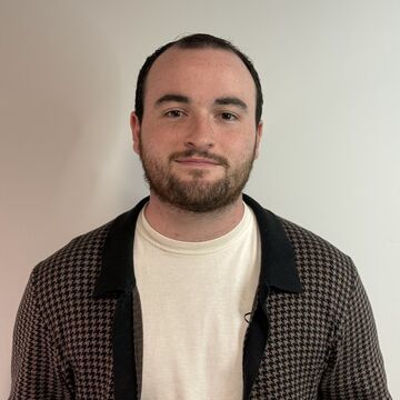 Portrait of Zach Robinson, an adult person with fair skin, short brown hair, and a beard.