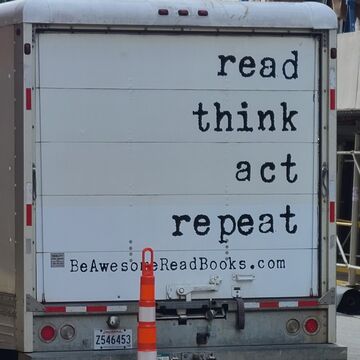 The back of a truck with text reading "read think act repeat. BeAwesomeReadBooks.com."
