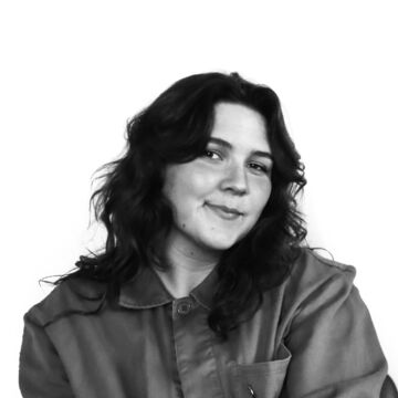 Black and white headshot of Brielle Stein, an adult person with a fair skin tone and medium-length black hair. 