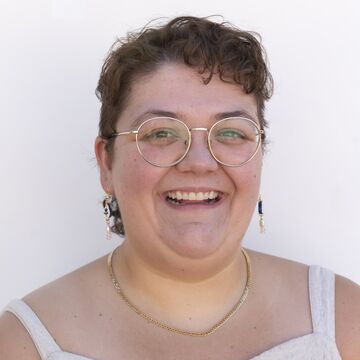 Rachael Buffett, an adult person with a fair skin tone, short brown hair, and glasses. 