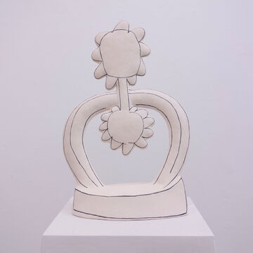 A white ceramic sculpture on a white surface.