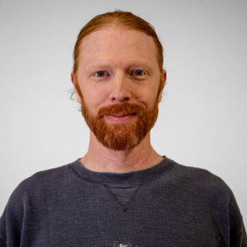 Headshot of Bowie Croisant, an adult person with a fair skin tone, ginger hair, and a beard.  
