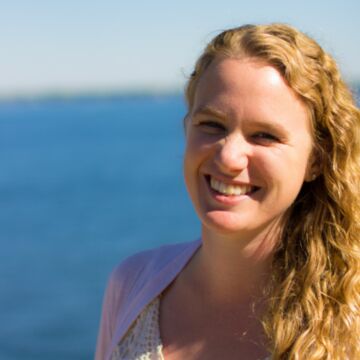 SAIC faculty member Lauren Johnson, a person with light skin tone and light wavy hair, standing outside.