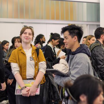 Students of varying ethnicities, ages, and genders gathered indoors. 