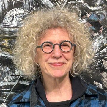 SAIC faculty member Olivia Petrides, a person with curly hair, light skin tone, and glasses.