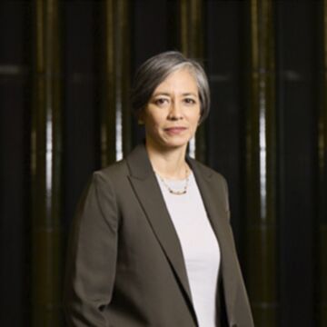 Headshot of Pauline Yao, an adult person with a medium-fair skin tone and short gray hair.
