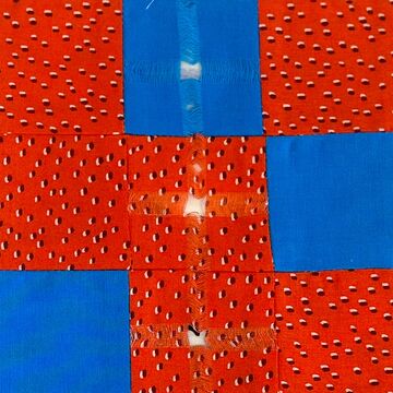 red and blue quilt with holes