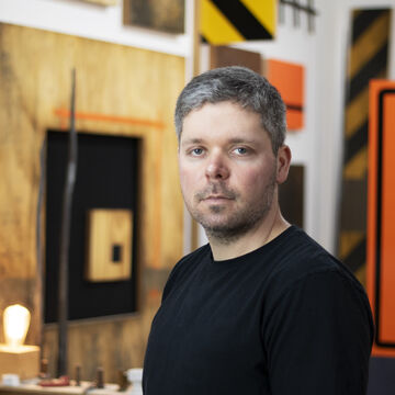 Headshot of Anthony Adcock, an adult person with a fair skin tone and short dark hair. 