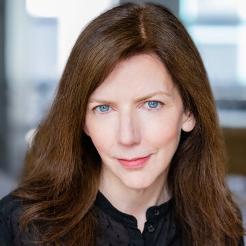 Headshot of Suzanne Scanlon, an adult person with a fair skin tone and medium length brown hair. 