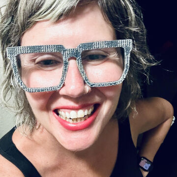 Selfie of Cassandra Smith, an adult person with a fair skintone, blonde hair, and glasses. 