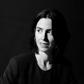 Black and white headshot of Maura Brewer, an adult person with a fair skintone and dark hair. 