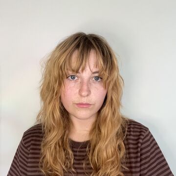 Ember Nevins, an adult person with a fair skintone and blonde hair. 