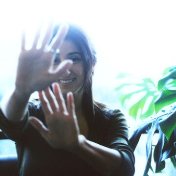 A photo of Pia Singh with their hands in front of the camera lens.