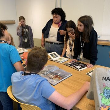 Middle School students at a table with books.