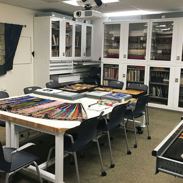 A variety of textiles are laid out on a table in the SAIC textile resource center