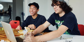 Two students working at a desk. 