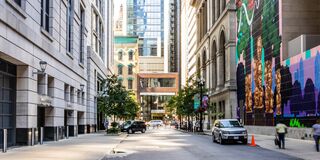City street with buildings, cars, and trees.