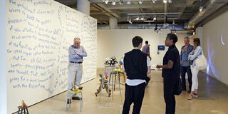 People standing and talking in art gallery