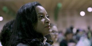 Still from a film of a Black woman in an audience