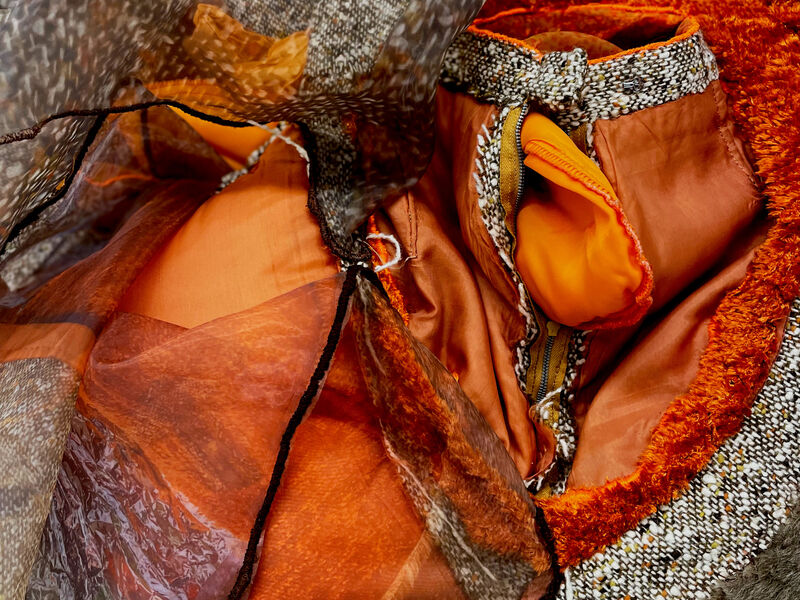 Detail shot of fiber manipulation in orange, biege, brown textiles.