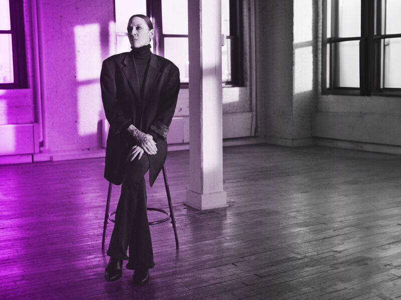 An artist sits on a stool in a loft