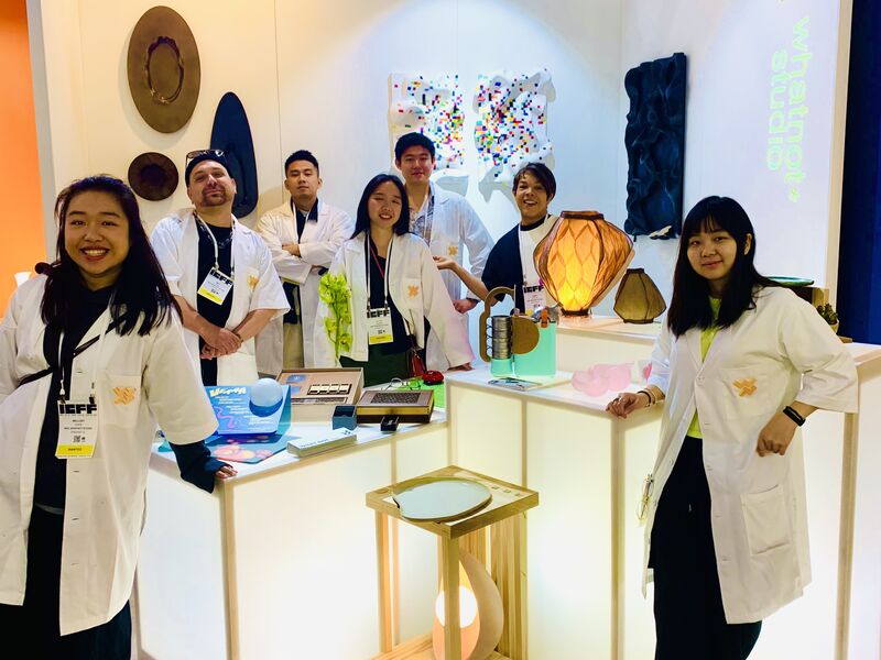 A group of students gathered in front of their designed products.