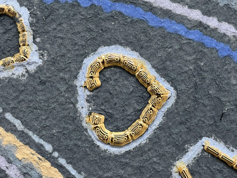 Detail of a gold, heart-shaped bamboo earring.