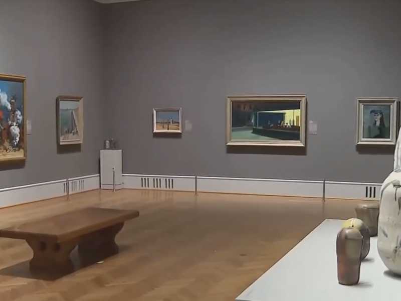 A view of a gallery with paintings hanging on the wall and sculptures at the Art Institute of Chicago.