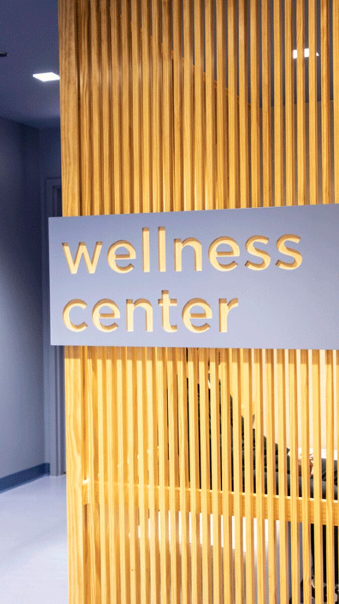 Sign hangs on wall reading “Wellness Center”. 