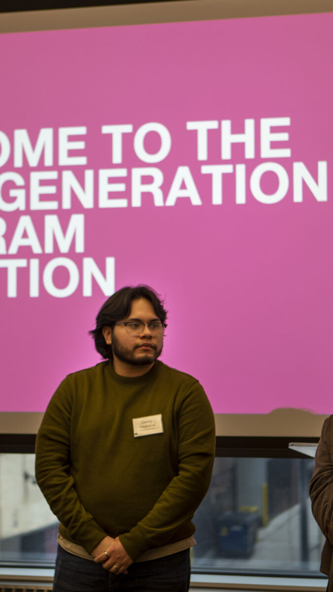 A group presenting in front of a large projection welcoming first-gen students