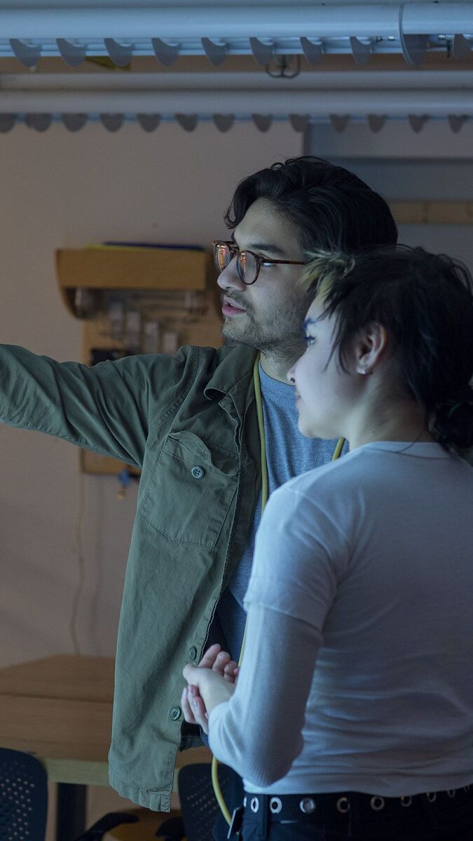 Two people observing and discussing a light installation. 