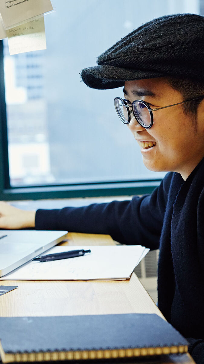 A person sitting at a desk working on their computer. 