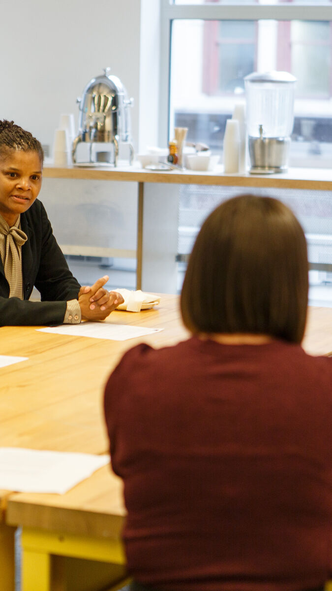 A person sitting with students at a table. 