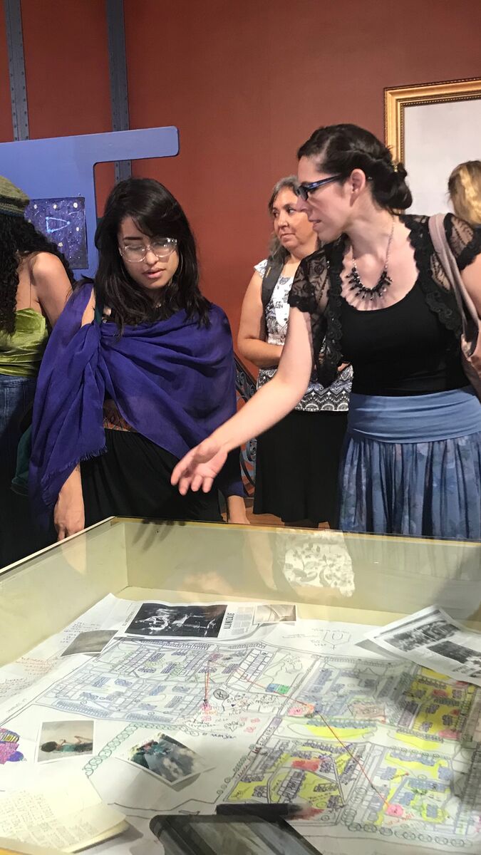 Students looking at art underneath glass.