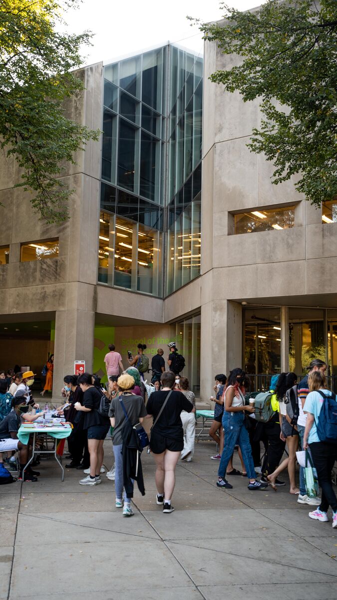 Group of students walking into a campus building during a student groups fair