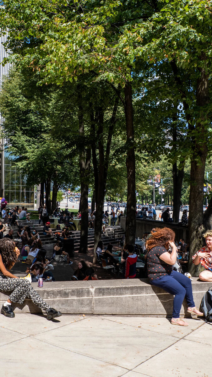 A large gathering of students sitting outside on the SAIC campus.