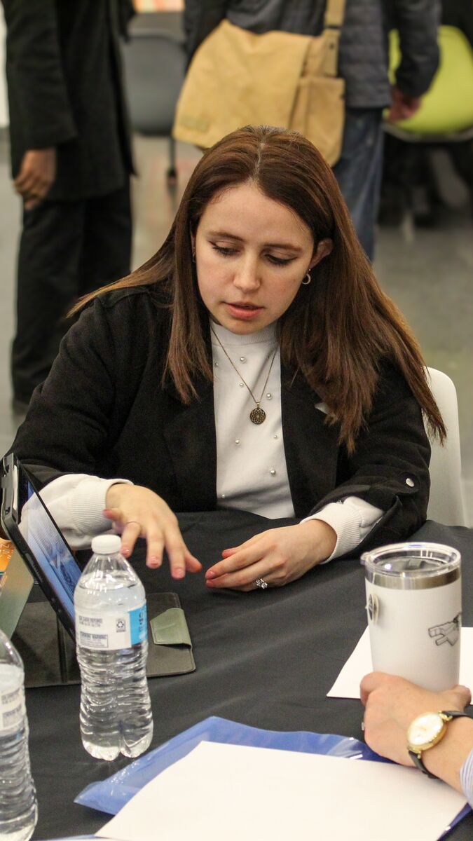 Two people seated and looking at an iPad. 