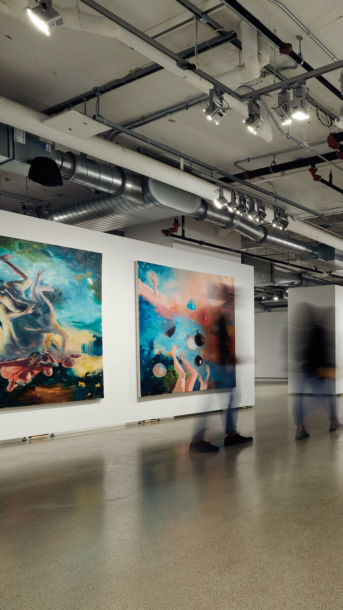 Two people walk through SAIC Galleries.