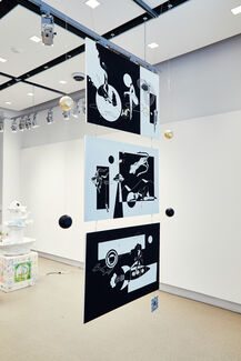 Three large black and white prints hung from the ceiling