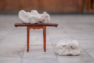 Two pieces of clay, one on the foundation of the image and another on a miniature table