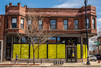 Exterior of a building on the corner of Morgan and 32nd with yellow and black paper fully obscuring the windows 