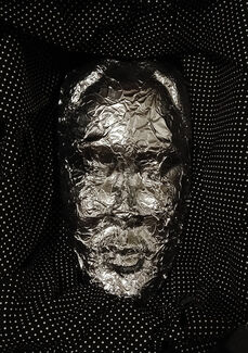 Image by Cecil McDonald, Jr. of a mask framed by polka dotted fabric.